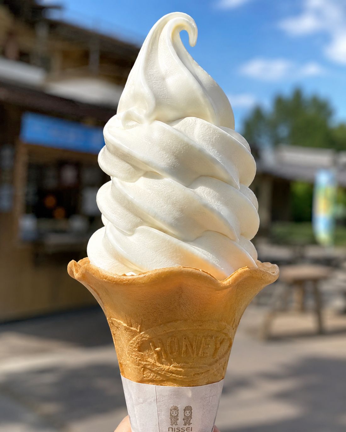 ワッフルコーンのバニラソフトクリーム。青空の下で食べる特別なご褒美